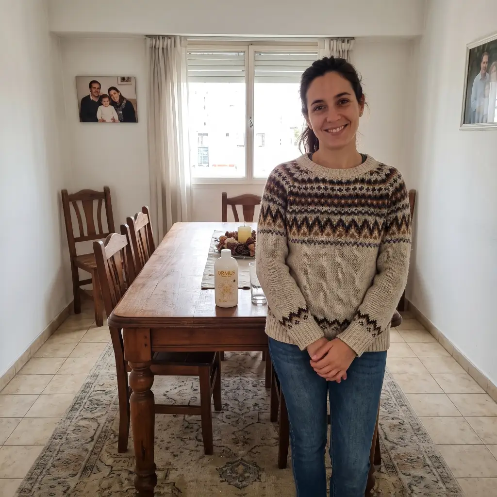En su departamento una mujer de unos 30 años está posando para la foto mientras en la mesa de atrás puede verse una botella de Ormus Patagonia
